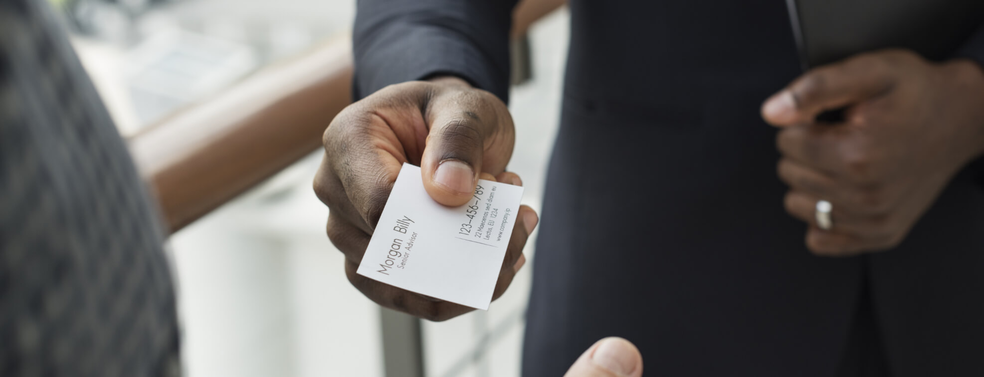 Man handing a high-quality business card to another person