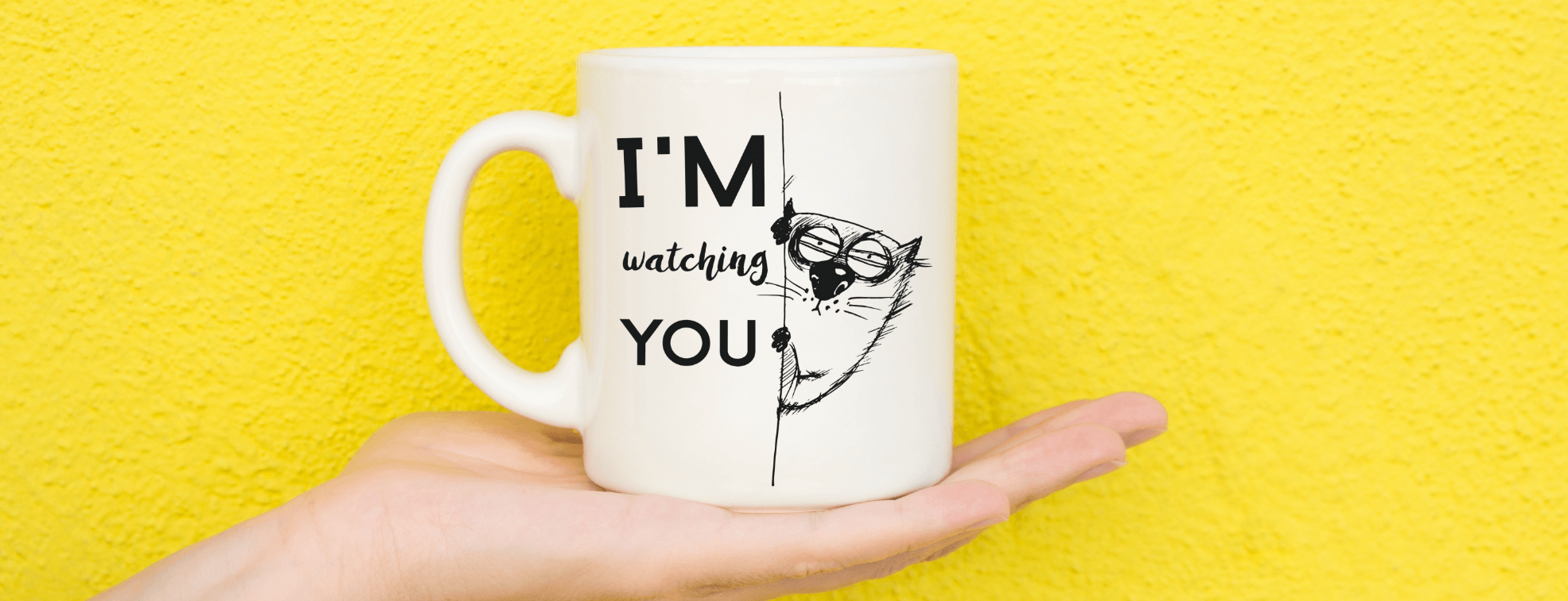 A funny mug on a yellow background with a cat watching you