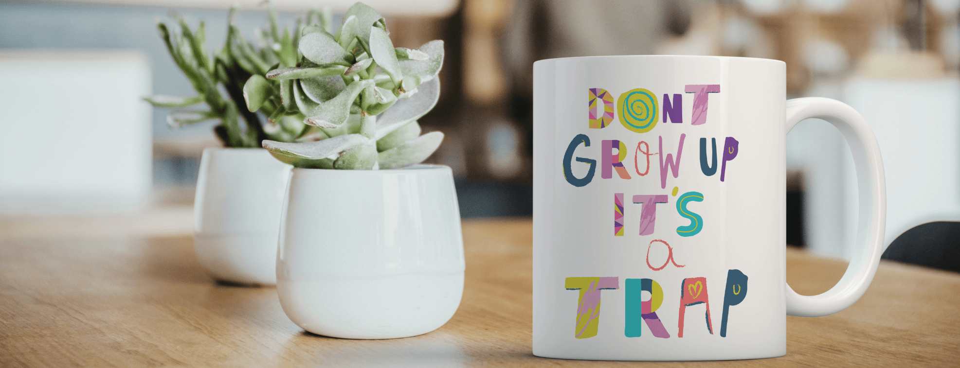 Cool custom white mug on a table with "Don't grow up it's a trap" written on it